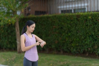 Güzel Asyalı kadın egzersiz koşusu için kollarını uzatıyor. Kadın, koşmadan ya da parkta egzersiz yapmadan önce ısınmak için kollarını uzatıyor..