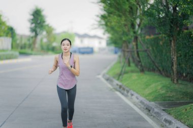 Güzel Asyalı kadın egzersiz koşusu için kollarını uzatıyor. Kadın, koşmadan ya da parkta egzersiz yapmadan önce ısınmak için kollarını uzatıyor..