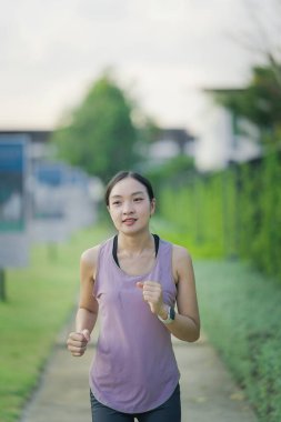 Güzel Asyalı kadın egzersiz koşusu için kollarını uzatıyor. Kadın, koşmadan ya da parkta egzersiz yapmadan önce ısınmak için kollarını uzatıyor..