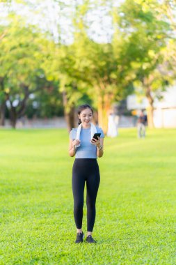 Güzel Asyalı kadın egzersiz koşusu için kollarını uzatıyor. Kadın, koşmadan ya da parkta egzersiz yapmadan önce ısınmak için kollarını uzatıyor..