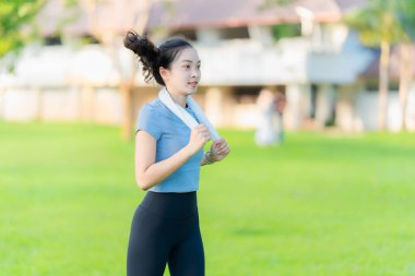 Güzel Asyalı kadın egzersiz koşusu için kollarını uzatıyor. Kadın, koşmadan ya da parkta egzersiz yapmadan önce ısınmak için kollarını uzatıyor..