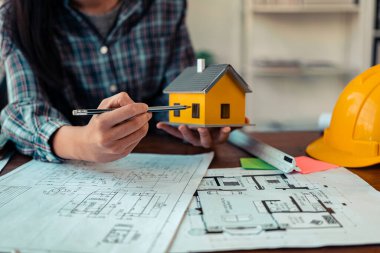 İnşaat mühendisleri ve mimarlar inşaat planlarını, proje ilerlemesini ve konut projesine yönelik tasarım planlarını tartıştılar.