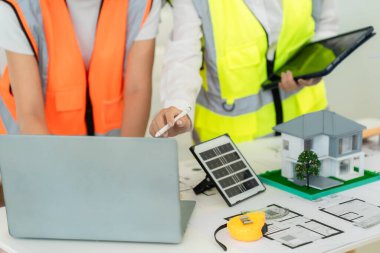 İnşaat mühendisleri ve mimarlar inşaat planlarını, proje ilerlemesini ve konut projesine yönelik tasarım planlarını tartıştılar.