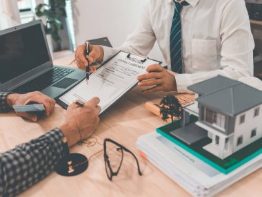 Emlak acentesinin işaret ettiği imza, kira sözleşmesi, satın alma, kiracıyla ev veya daire satın alma, banka, ipotek, kredi, tamamlama, fotoğraf kapama.