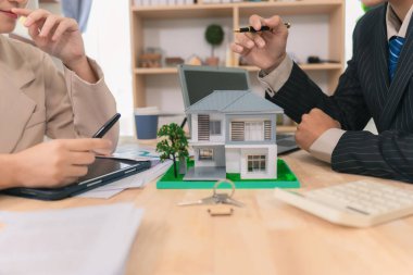 Asyalı çift gayrimenkul alımı, sözleşme belgeleri, pazarlıklar, finansman ve gelecekteki ev sahipliği planlarıyla ilgili görüşmeler yapıyor..