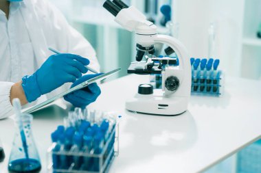 Healthcare researchers working with microscopes in biological science laboratories, technology and medical research to test vaccines.