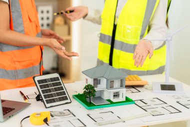 Mimarlar ve mühendisler, bina cephesini tartışmak için ev ve mağazaların, inşaat ofislerinin tasarım planlarını gösteriyorlar..