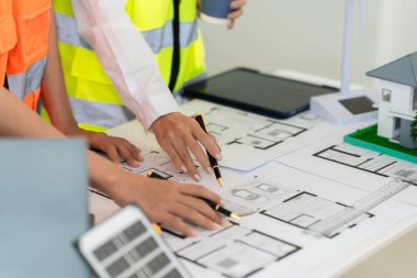 Mimarlar ve mühendisler, bina cephesini tartışmak için ev ve mağazaların, inşaat ofislerinin tasarım planlarını gösteriyorlar..