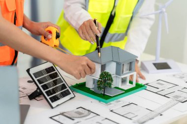 Mimarlar ve mühendisler, bina cephesini tartışmak için ev ve mağazaların, inşaat ofislerinin tasarım planlarını gösteriyorlar..