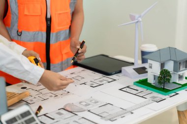 Mimarlar ve mühendisler, bina cephesini tartışmak için ev ve mağazaların, inşaat ofislerinin tasarım planlarını gösteriyorlar..