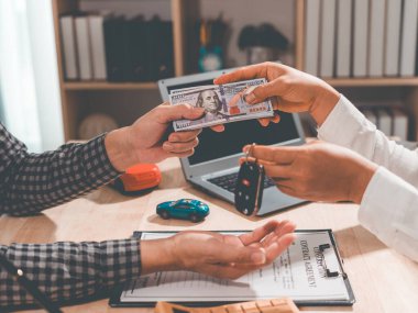 Araba galerisi, bir araba kredisinin faiz oranlarını ve maliyetlerini, sözleşmenin şartları ve koşulları ile birlikte ofislerinde hesaplar. (Resim yakın plan)