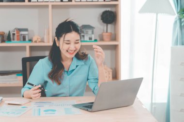 Asyalı bir iş kadını, bir gayrimenkul projesinde kararlaştırılan gelirin finansal onayını öğrenince neşeli ve heyecanlı bir ifade sergiledi..