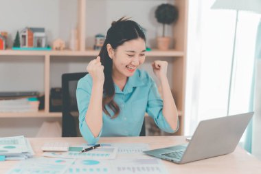 Asyalı bir iş kadını, bir gayrimenkul projesinde kararlaştırılan gelirin finansal onayını öğrenince neşeli ve heyecanlı bir ifade sergiledi..