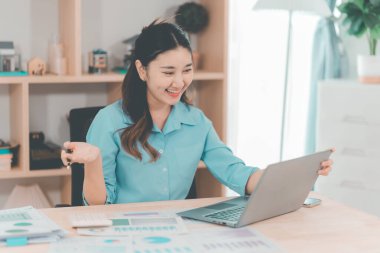 Asyalı bir kadın muhasebeci masasında çalışırken şiddetli bir ağrı yaşadı. Bu da kötü bir duruş ya da uzun süre oturma durumu olduğunu gösteriyor..