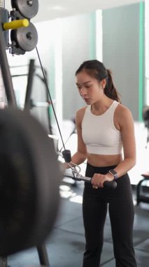 Kararlı ve güçlü bir Asyalı kadın spor salonundaki spor salonunda ağırlık kaldırıyor. Vücut çalışıyor, kas yapmak için ağırlık çalışıyor ve kaldırıyor sağlıklı bir yaşam tarzı konsepti..