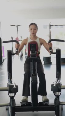 Kararlı ve güçlü bir Asyalı kadın spor salonundaki spor salonunda ağırlık kaldırıyor. Vücut çalışıyor, kas yapmak için ağırlık çalışıyor ve kaldırıyor sağlıklı bir yaşam tarzı konsepti..