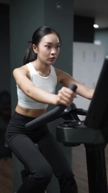 Kararlı ve güçlü bir Asyalı kadın spor salonundaki spor salonunda ağırlık kaldırıyor. Vücut çalışıyor, kas yapmak için ağırlık çalışıyor ve kaldırıyor sağlıklı bir yaşam tarzı konsepti..