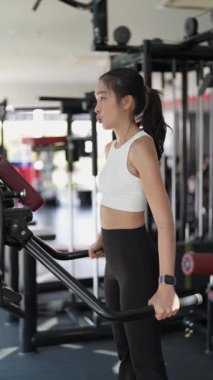 Kararlı ve güçlü bir Asyalı kadın spor salonundaki spor salonunda ağırlık kaldırıyor. Vücut çalışıyor, kas yapmak için ağırlık çalışıyor ve kaldırıyor sağlıklı bir yaşam tarzı konsepti..