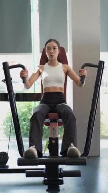 Kararlı ve güçlü bir Asyalı kadın spor salonundaki spor salonunda ağırlık kaldırıyor. Vücut çalışıyor, kas yapmak için ağırlık çalışıyor ve kaldırıyor sağlıklı bir yaşam tarzı konsepti..