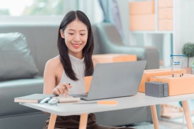 Kadınlar evden iş ortamında küçük işletmeler için karton kutular hazırlıyorlar; girişimciler çevrimiçi siparişler göndermeye hazırlanıyorlar; KOBİ iş fikirleri.