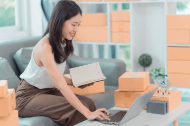 Kadınlar evden iş ortamında küçük işletmeler için karton kutular hazırlıyorlar; girişimciler çevrimiçi siparişler göndermeye hazırlanıyorlar; KOBİ iş fikirleri.