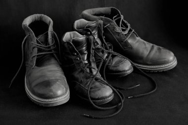 Bir çift yetişkin botu ve bir çift çocuk botu siyah ve beyaz olarak birlikte..