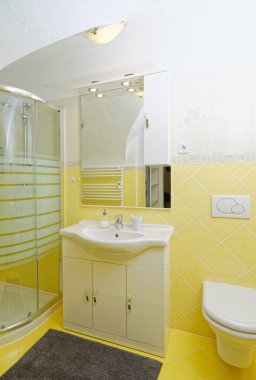 Evdeki modern sarı banyo.