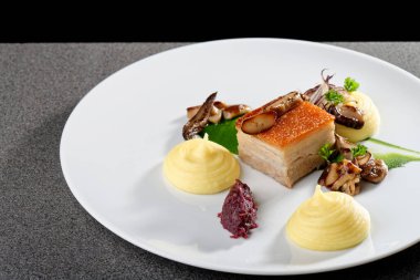 Taze ızgara domuz eti, patates ve mantarla kaplanmış.