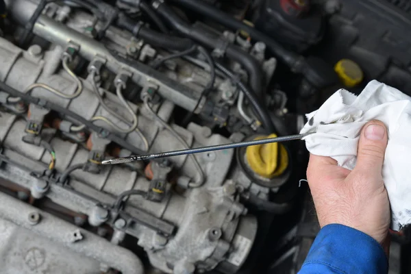Auto mechanic checking engine oil level. — Stock Photo, Image
