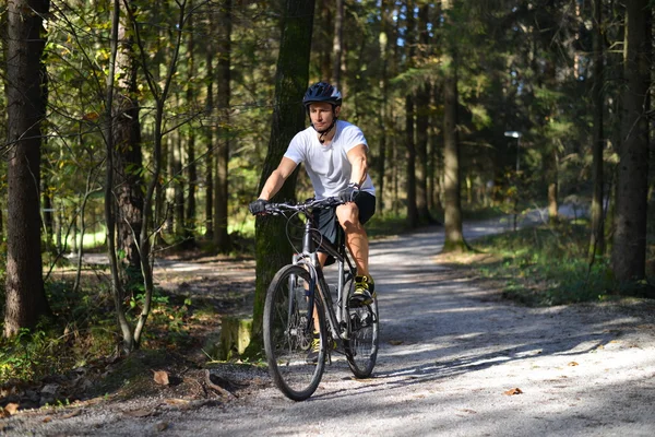 Ciclista cavalca attraverso la foresta — Foto Stock