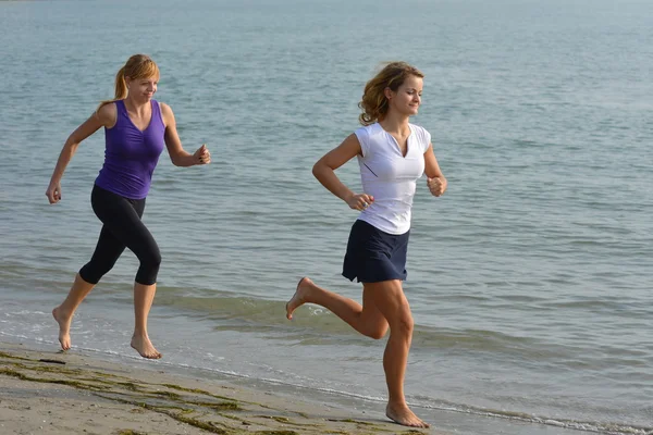 Twee mooie meisjes joggen — Stockfoto