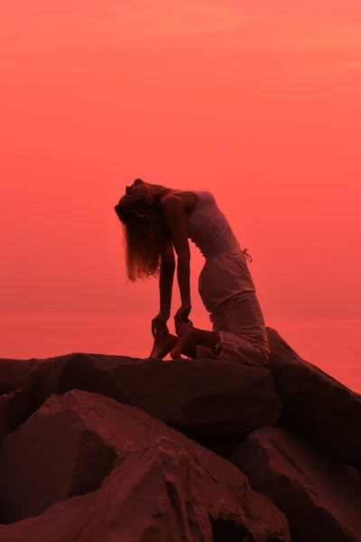 Femme yoga posant au coucher du soleil — Photo