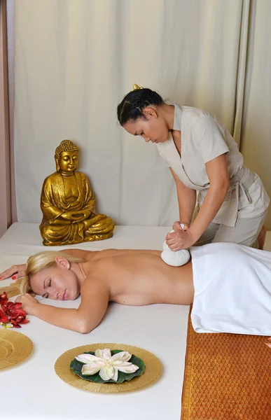 Young beautiful female receiving herbal ball massage — Stock Photo, Image