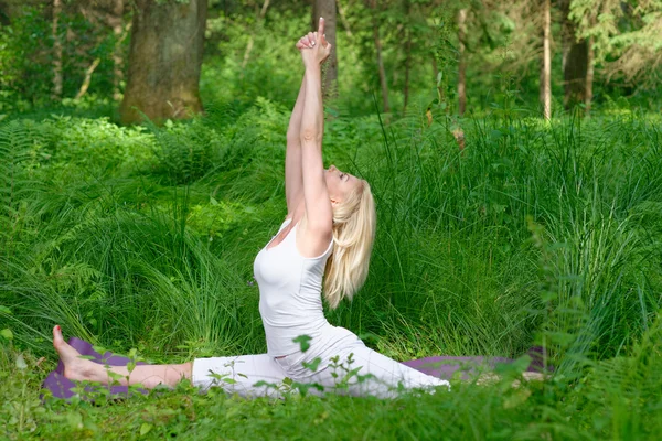 Женщина практикует йогу в природе — стоковое фото