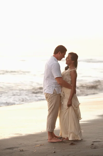 Bride and groom against the blue ocean — Stock Photo, Image