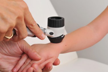 Dermatologist examines child clipart