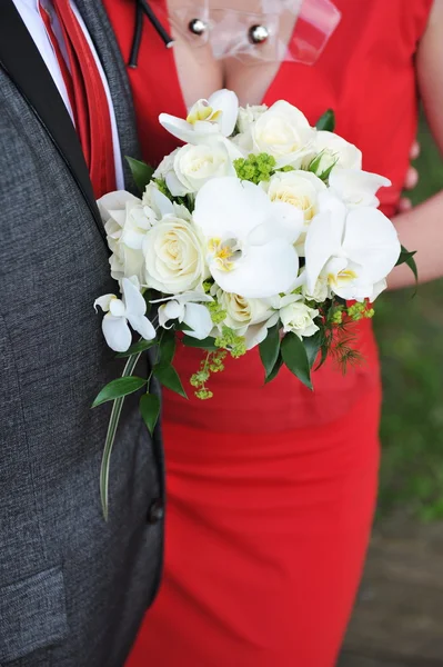 Braut und Bräutigam halten Blumenstrauß — Stockfoto