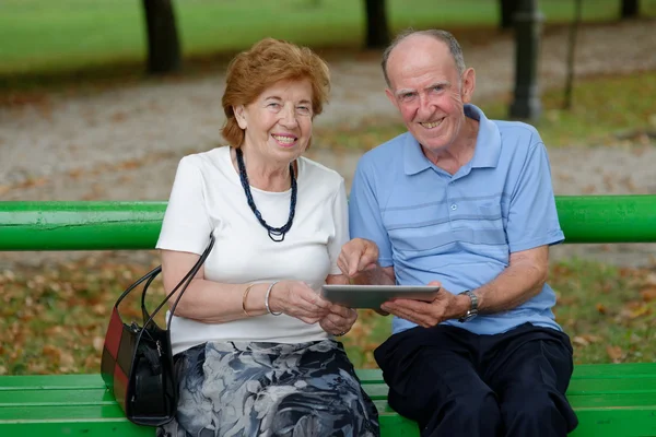 Twee senior mensen zitten met een tablet Pc — Stockfoto