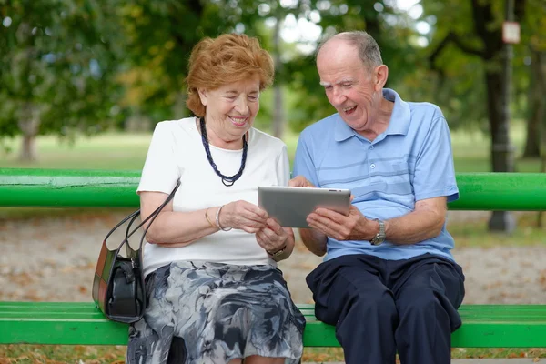 Twee senior mensen zitten met een tablet Pc — Stockfoto