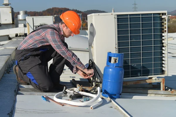 Joven reparador que fija el sistema de aire acondicionado — Foto de Stock