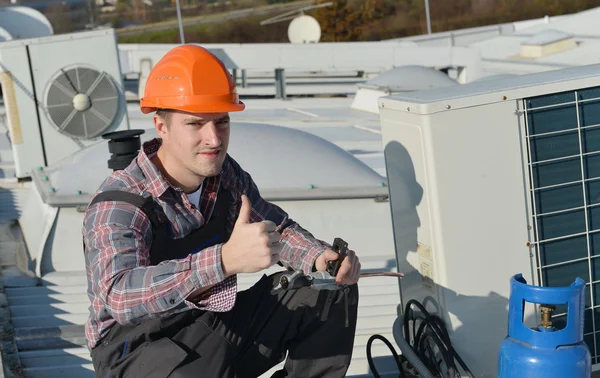Молодой ремонтник, ремонтирующий систему кондиционирования воздуха — стоковое фото