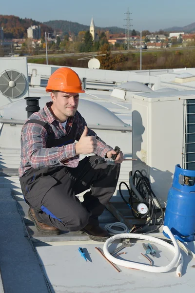 Unga reparatör fästande luftkonditioneringssystem — Stockfoto