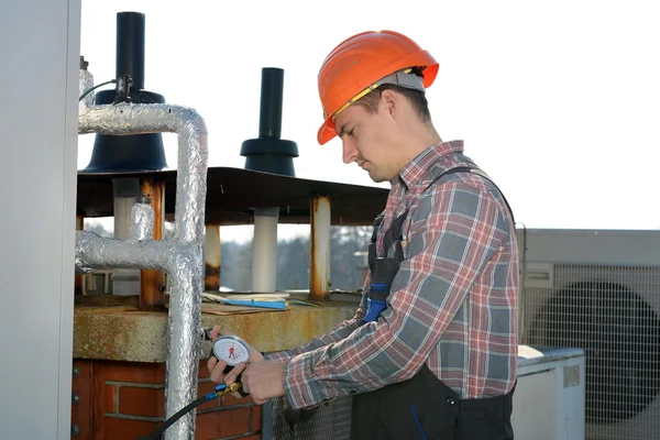 Joven reparador que fija el sistema de aire acondicionado — Foto de Stock