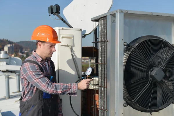 Young repairman fixing air conditioning system