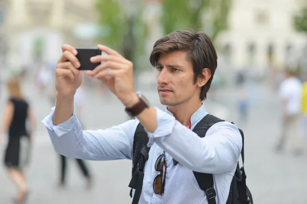 Joven hombre guapo fotografiando con móvil — Foto de Stock