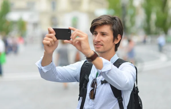 Joven hombre guapo fotografiando con móvil — Foto de Stock