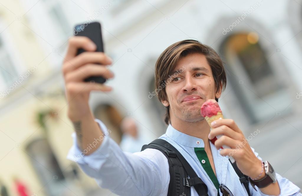 Portrait of handsome young man eating ice cream