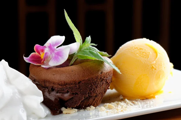 Chocolate souffle with mango ice cream and coconut foam — Stock Photo, Image