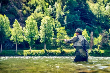 Katalan Pireneleri 'nin nehirlerinde balıkçı alabalığı ve somon balığı avlayan tüm balıkçı ekipmanlarıyla birlikte.