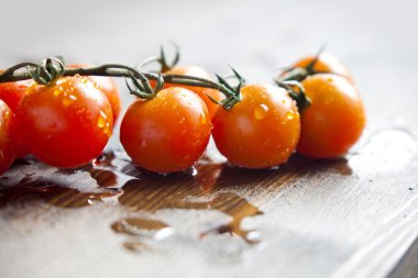 Kesme tahtasında bir dal kiraz domatesi.